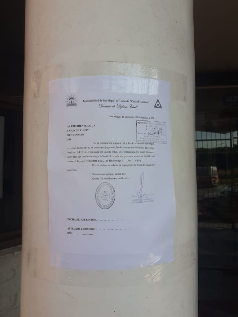 La nota de la Dirección de Defensa Civil pegada en el pilar de entrada de la Unión de Rugby de Tucumán. 